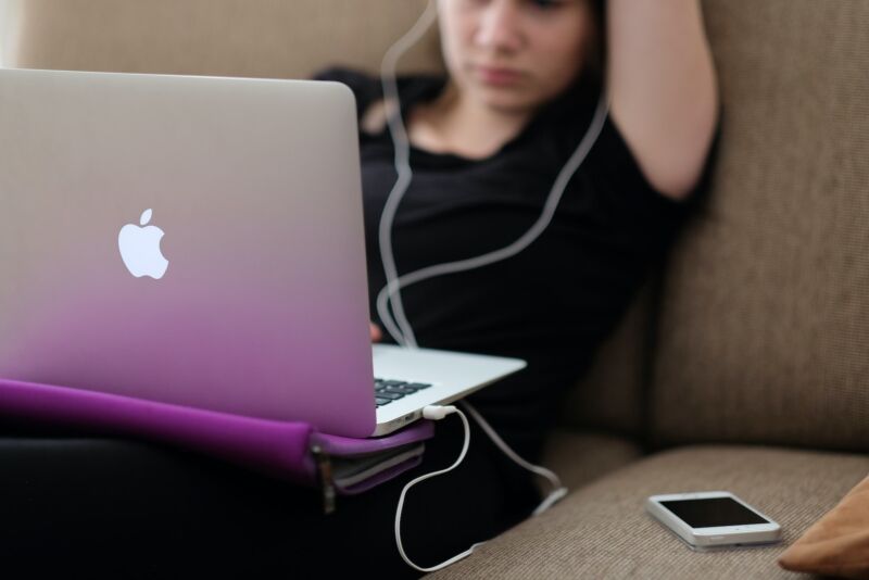 teen sitting on sofa with MacBook Air