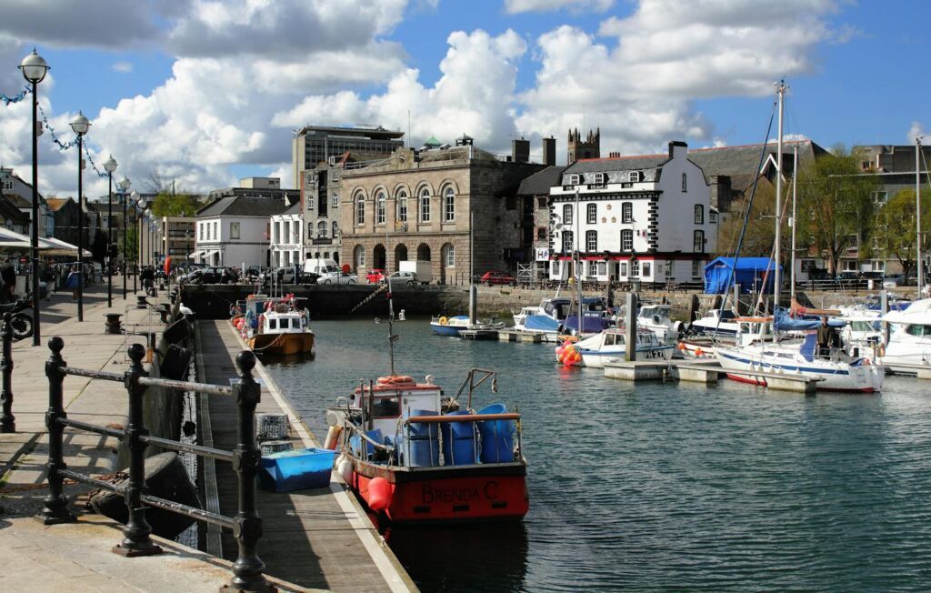 A picturesque harbour with boats and historic buildings on a sunny day.