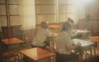 A group of people sitting at desks in a room