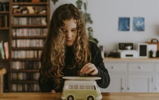 girl wearing black sweatshirt playing toy car