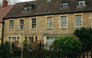Old stone building with dormer windows and trees