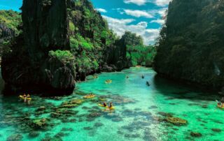 a group of people in a body of water surrounded by large rocks