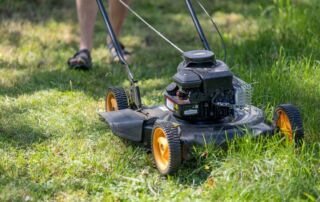 a person mowing the grass with a lawn mower