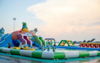 People enjoying a colorful inflatable water park.