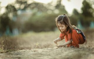 girl playing sand during daytime