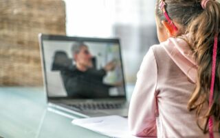 woman in pink long sleeve shirt sitting in front of macbook pro